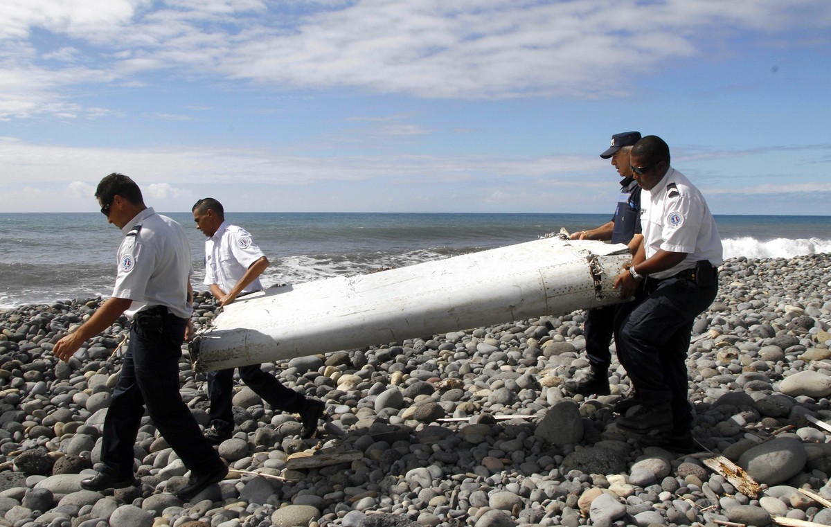epa04911079 (FILE) A file photo dated 29 July 2015 showing officers carrying a flaperon from an aircraft apparently washed ashore in Saint-Andre de la Reunion, eastern La Reunion island, France. Frenc ...