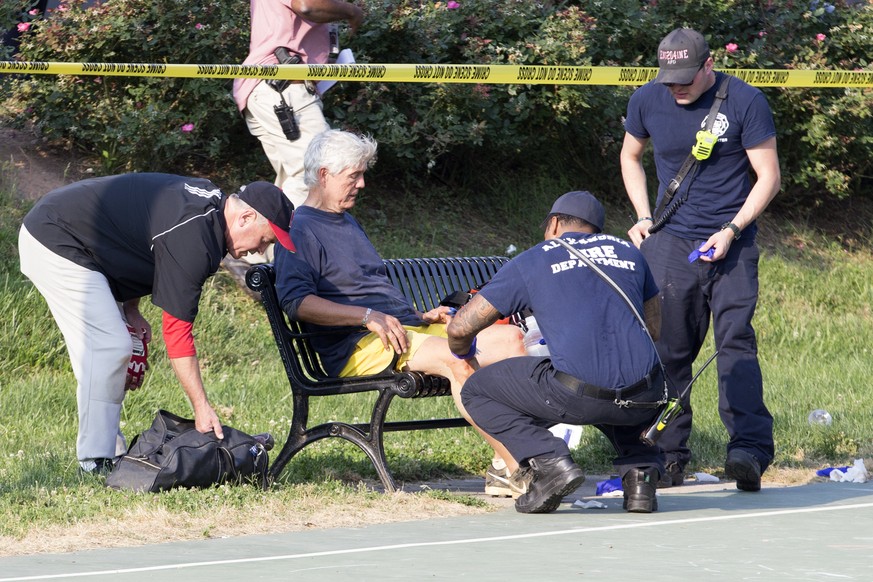 epa06027761 A man receives medical attention from first responders on the scene following a shooting in Alexandria, Virginia, USA, 14 June 2017. Republican Representative Steve Scalise and two Capitol ...