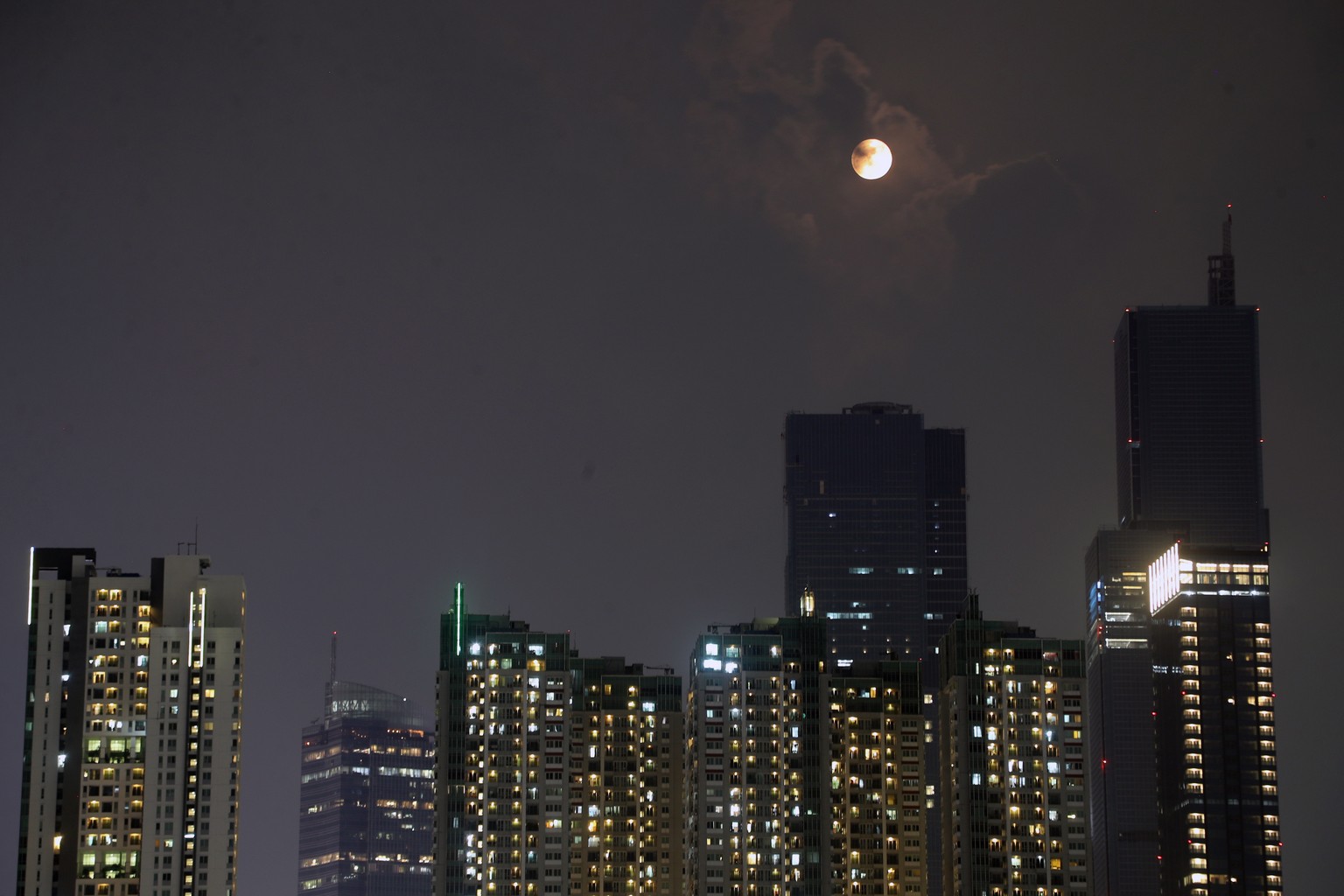 epa10830908 A rare Super Blue Moon rises over the buildings in Jakarta, Indonesia, 31 August 2023. A 'Supermoon' occurs when the Moon comes to its closest point to the Earth. This second Sup ...