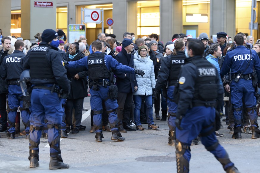 Leute demonstrieren gegen die Corona-Schutzmassnahmen des Bundes und werden von Polizisten ueberwacht, am Samstag, 19. Dezember 2020, auf dem Bundesplatz in Bern. (KEYSTONE/Anthony Anex)