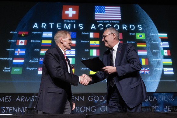 epa11280700 Swiss Federal Councillor Guy Parmelin (R) and NASA Administrator Bill Nelson (L) shake hands during the Switzerland Artemis Accords signing ceremony, at the National Aeronautics and Space  ...