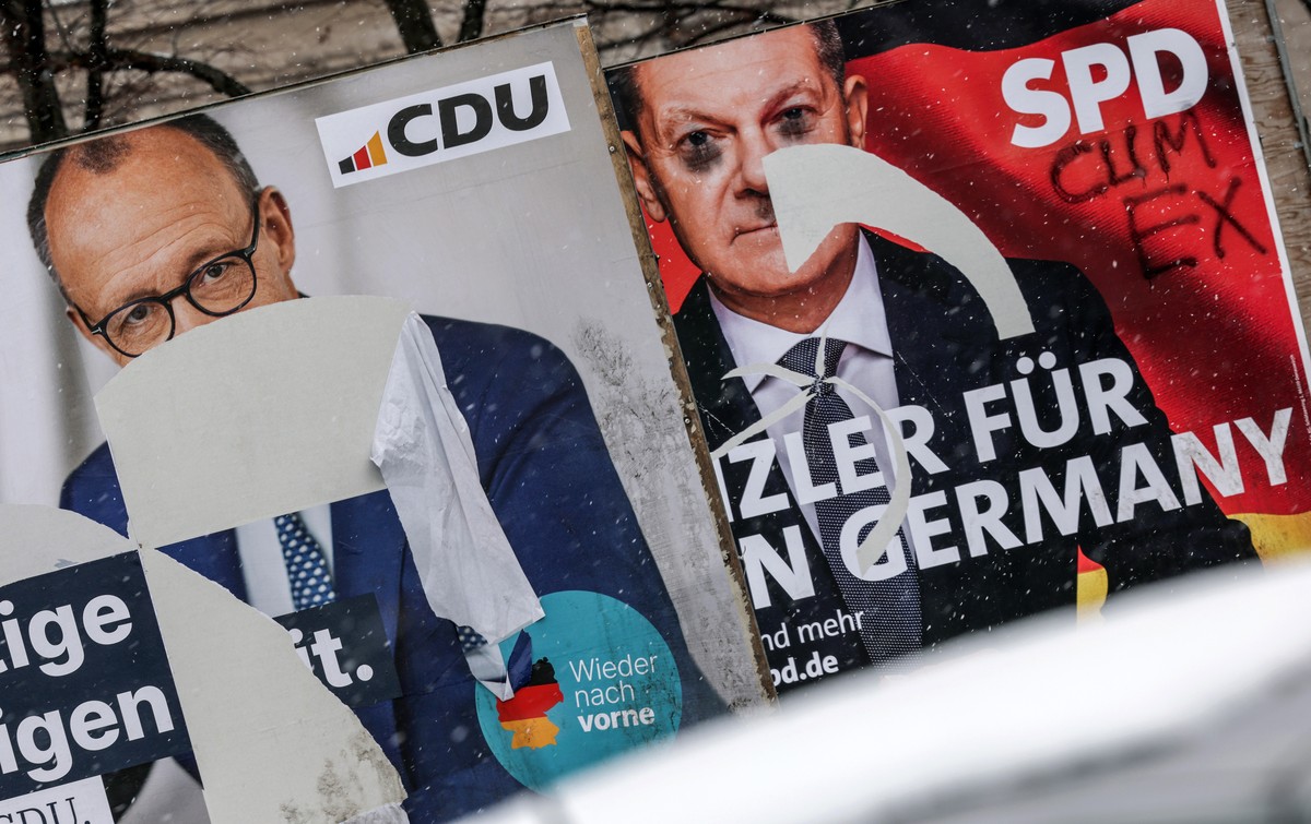 epaselect epa11900155 Damaged election campaign posters of incumbent German Chancellor and Social Democratic Party (SPD) leader Olaf Scholz (R) and Christian Democratic Union (CDU) leader Friedrich Me ...