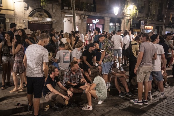 People talk and drink in downtown Barcelona, Spain, early Sunday, July 4, 2021. (AP Photo/Joan Mateu)