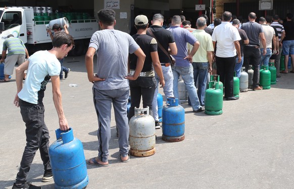 epa09426038 People queue to refill domestic gas cylinders at a domestic gas station, in the Ouzai area, Beirut, Lebanon, 23 August 2021. The fuel crisis, during the year 2021, has reached an acute lev ...