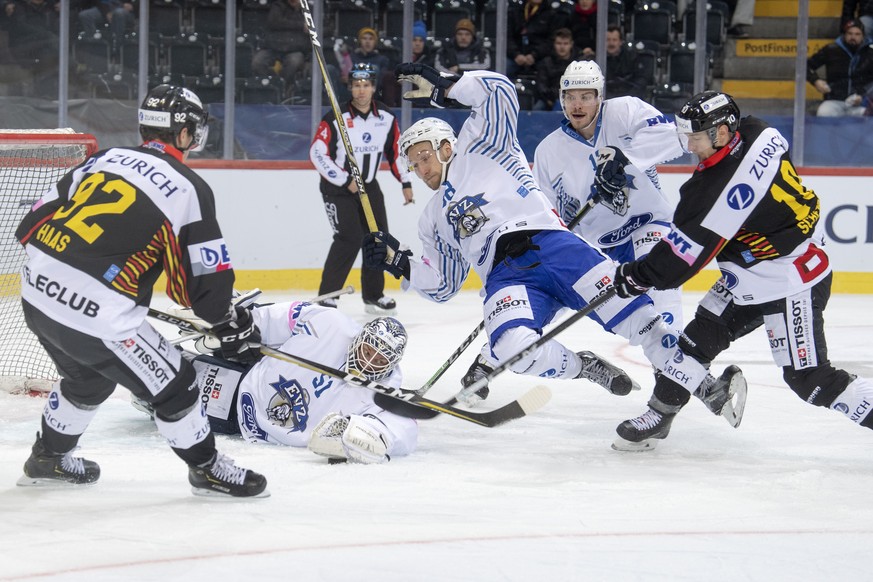 Berns, Gaetan Haas, links, und Tristan Scherwey im Kampf um den Puck gegen Zugs, Goalie Tobias Stephan, und Jesse Zgraggen, Mitte, waehrend dem Halbfinalspiel des Swiss Ice Hockey Cups zwischen dem SC ...