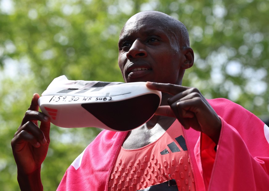 epa12914821 Sabastian Sawe of Kenya poses with a shoe after he wins the London Marathon with a World Record and the first sub two-hour marathon time of 1:59:30 h during the London Marathon in London,  ...