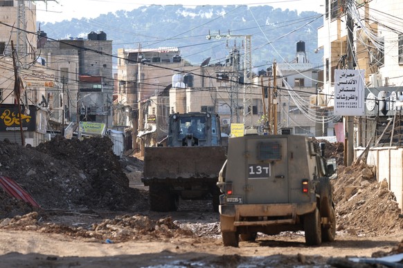 epa11963987 Israeli army vehicles block a road during an Israeli military operation in the West Bank city of Jenin, 14 March 2025. The Israeli military launched a military operation in Jenin and its c ...