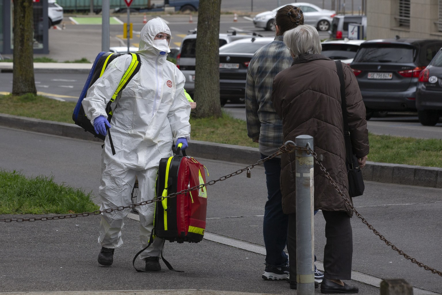 A paramedic wearing protective gear as a precaution against the spread of the coronavirus COVID-19 speaks to patient suspected of having contracted the Covid-19 virus before he will be taken to a hosp ...