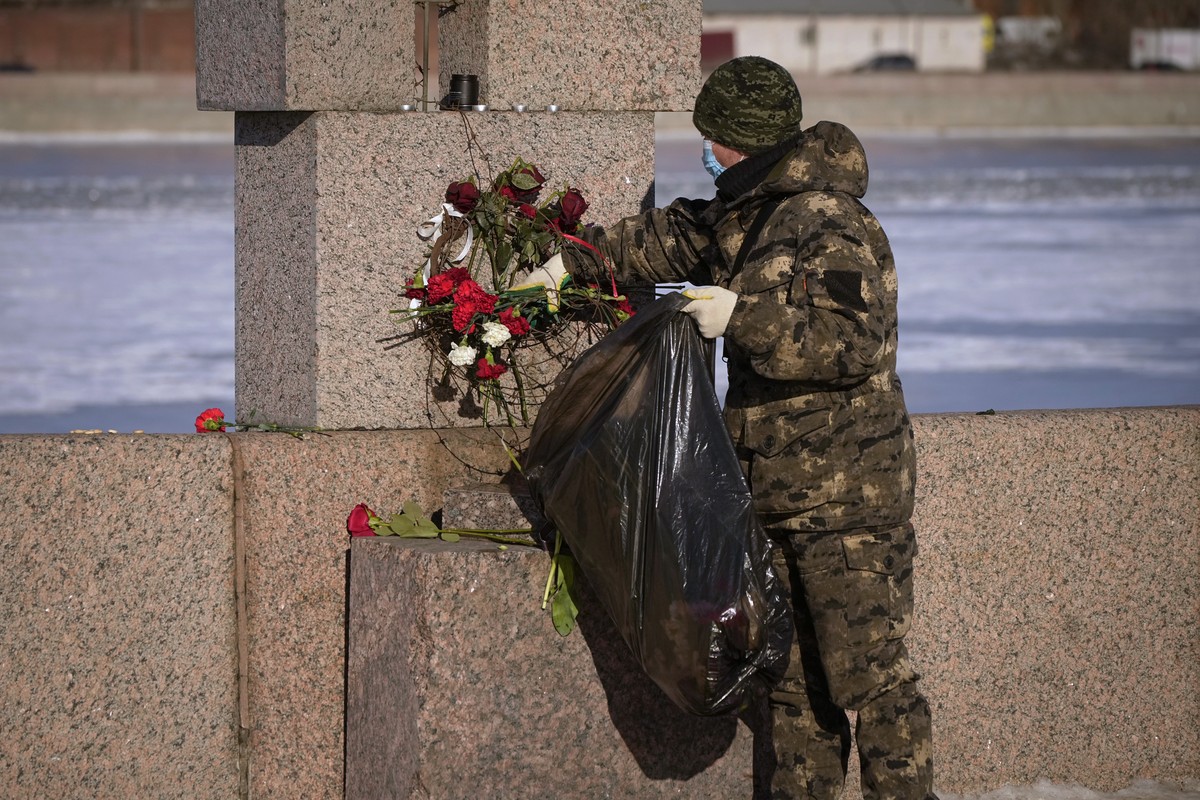 A municipal worker, on orders from the authorities, removes flowers brought by people to pay respect to Alexei Navalny from the Memorial to Victims of Political Repression in St. Petersburg, Russia, M ...