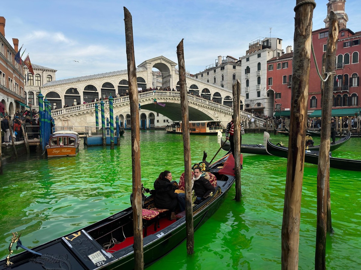 epa11019596 The waters of Canal Grande is turned green with fluorescein, a harmless substance, by climate activists of the 'Extinction Rebellinon' group, during their climate protest in Veni ...