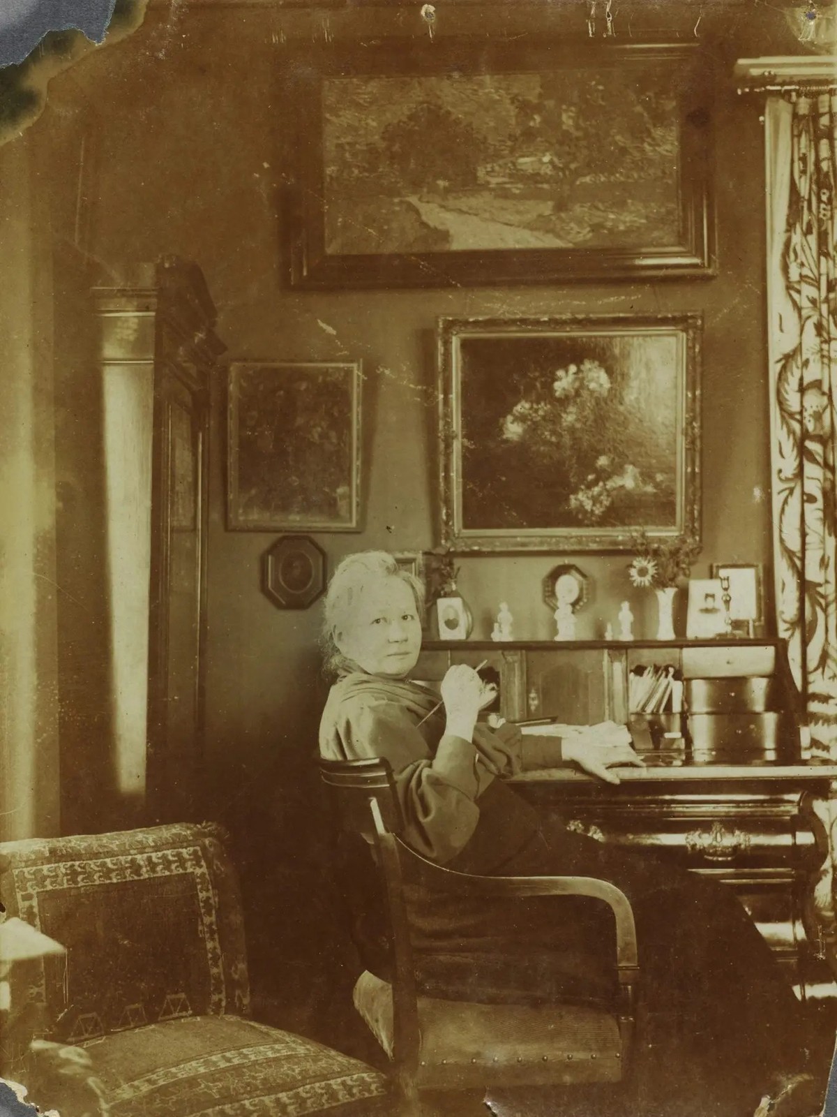 Jo van Gogh-Bonger im Wohnzimmer ihres Hauses am Koniginnenweg 77 in Amsterdam (1990 oder später). An der Wand über dem Sekretär zwei Bilder von Schwager Vincent, «Vase mit Mondviolen» (1884) und «Lan ...