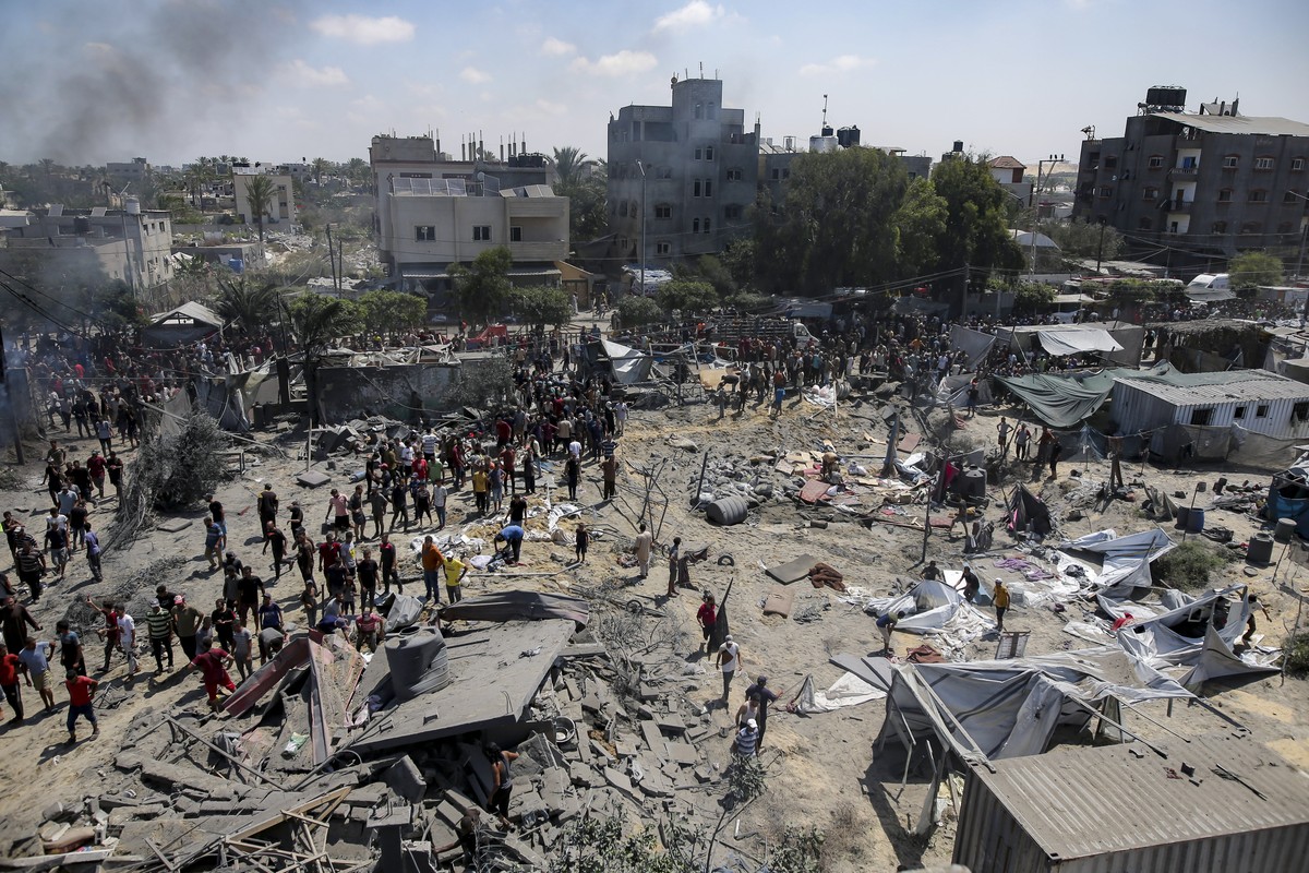 Palestinians inspect the damage at a site hit by an Israeli bombardment on Khan Younis, southern Gaza Strip, Saturday, July 13, 2024. Israel said it targeted Hamas' shadowy military commander in  ...