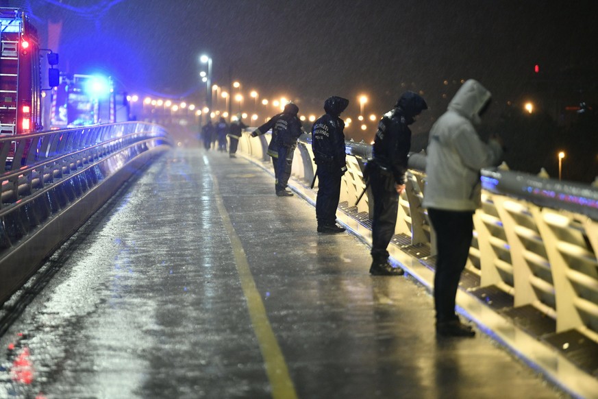 Rescuers and police officers inspect the River Danube from a landing dock after a tourist boat crashed with another ship late Wednesday, May 29, 2019. The boat capsized and sunk in the Danube River We ...