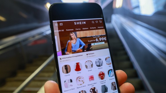 epa12749294 The Shein website is displayed on a smartphone in front of the European Commission headquarters in Brussels, Belgium, 17 February 2026. The European Commission is expected to provide a for ...