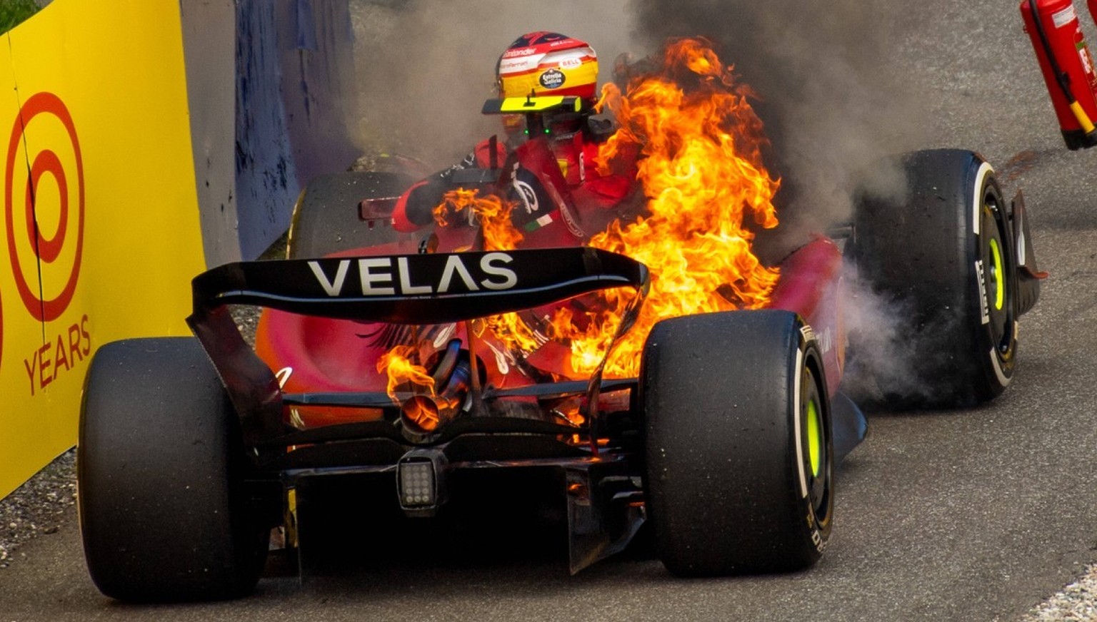 Carlos Sainz kann sich gerade noch aus deinem brennenden Boliden befreien.