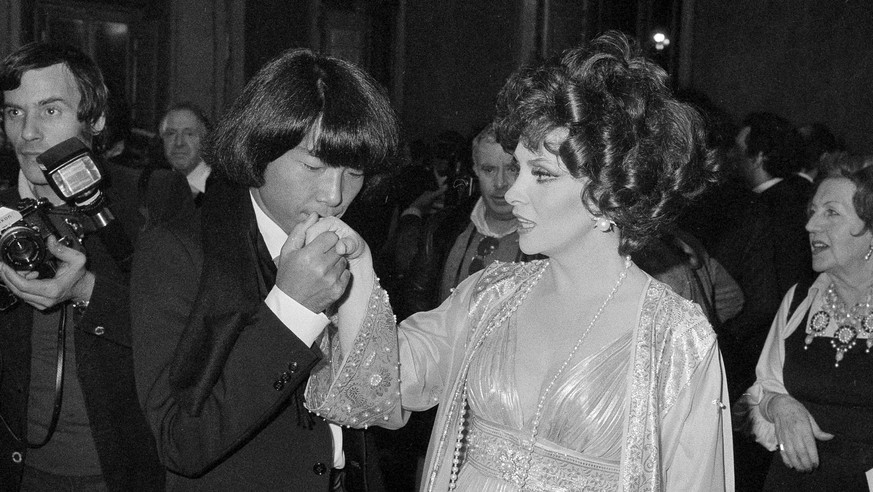 FILE - In this Dec. 16, 1977 file photo, designer Kenzo Takada kisses the hand of Italian actress Gina Lollobrigida after she awarded him as one of the ten most elegant men in the world in Rome, Italy ...