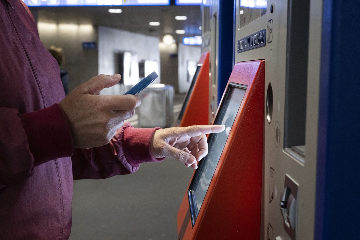 Eine Frau bezahlt an einem SBB Billettautomaten mit ihrem Smartphone, fotografiert am Montag, 1. Juli 2024 am Bahnhof Oerlikon in Zuerich. (KEYSTONE/Christian Beutler)