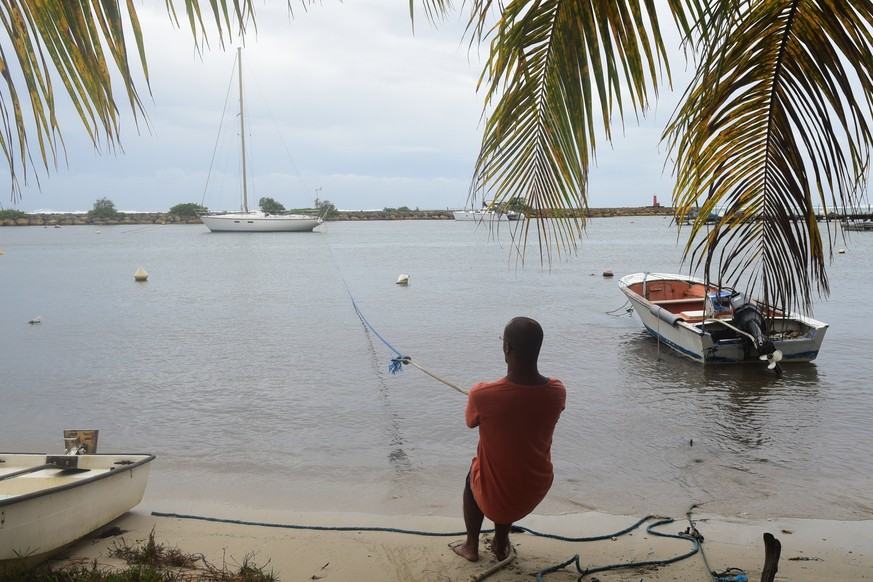 A man pulls in a boat ahead of Hurricane Maria in the Galbas area of Sainte-Anne on the French Caribbean island of Guadeloupe, early Monday, Sept. 18, 2017. Hurricane Maria grew into a Category 3 stor ...