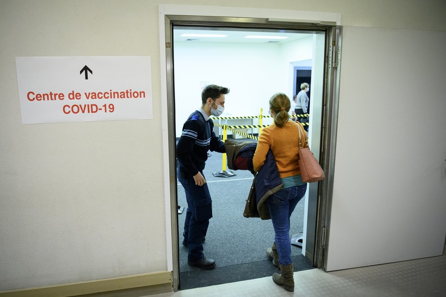 Une personne est accueillie par un Securitas a l&#039;0entree du centre de vaccination Covid-19 lors de l&#039;ouverture des centres de vaccination dans le canton de Vaud pendant la pandemie de Corona ...