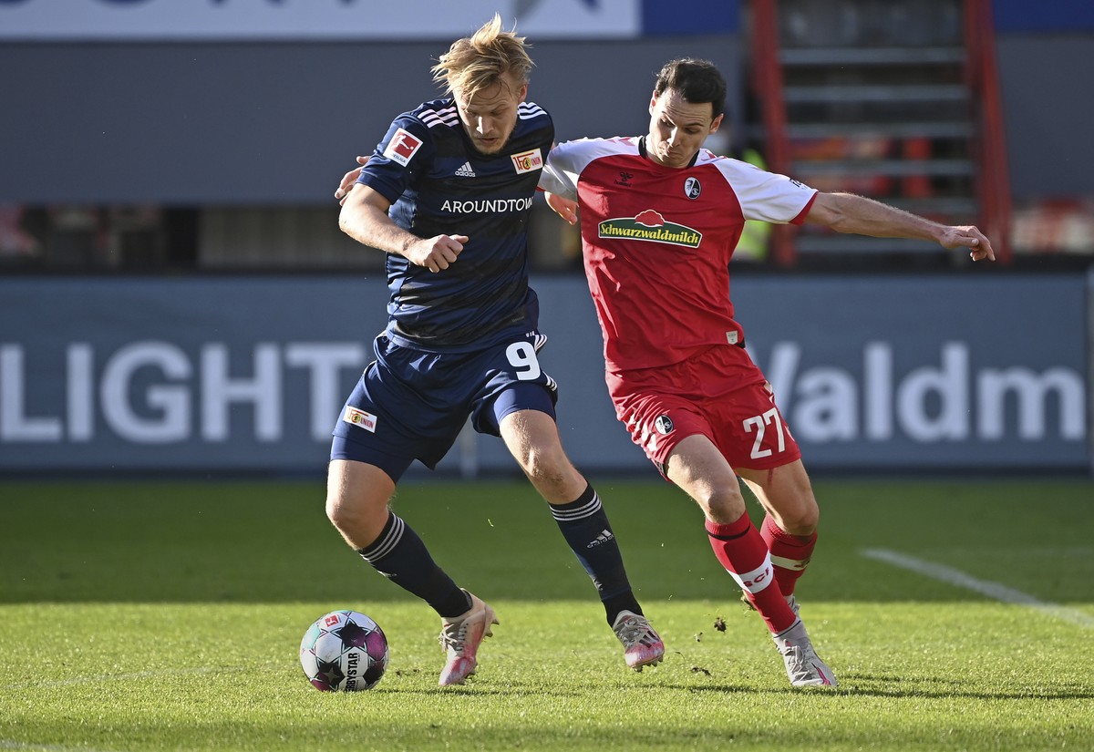 Berlin's Joel Pohjanpalo, left, and Freiburg's Nicolas Hoefler challenge for the ball during the German Bundesliga soccer match between SC Freiburg and 1. FC Union Berlin in Freiburg, German ...