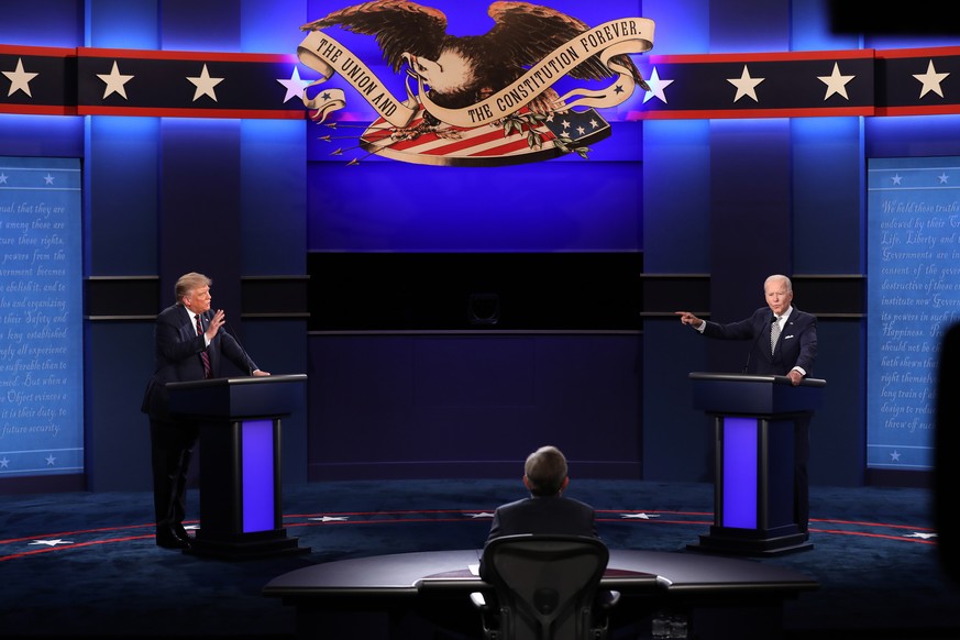 epa08707294 US President Donald J. Trump (L) and Democratic presidential candidate Joe Biden (R) participate with Moderator Chris Wallace (C) in the first 2020 presidential election debate at Samson P ...