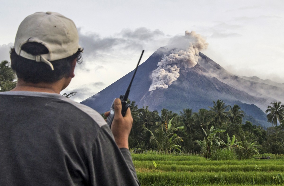 A volunteer uses his walkie talkie as he monitors Mount Merapi during an eruption in Sleman, Wednesday, Jan. 27, 2021. Indonesia's most active volcano erupted Wednesday with a river of lava and s ...
