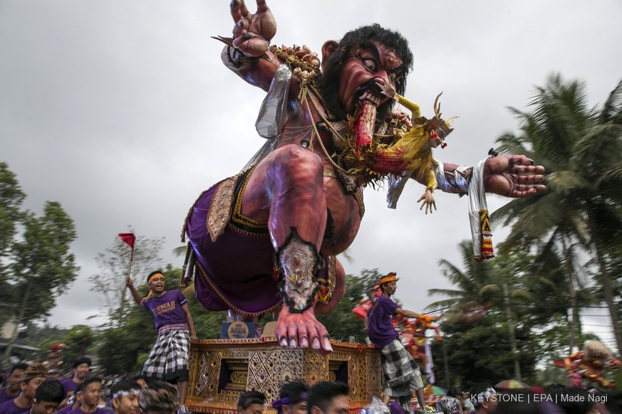 epa06605952 Balinese carry giant effigies in the form of the devil, whose local name is &#039;Ogoh-ogoh&#039;, during a parade before Nyepi Day, the Balinese Day of Silence, that marks the Balinese Hi ...