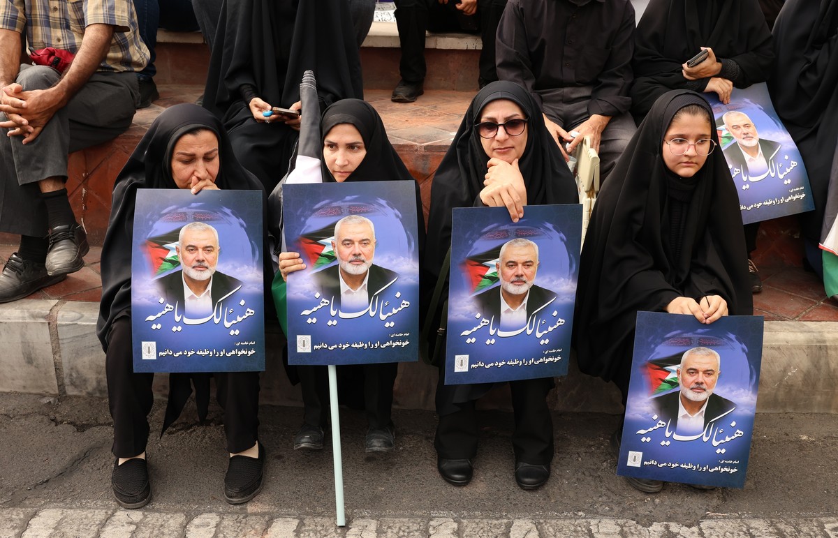 epa11514422 Iranian women hold pictures of Hamas late political leader Ismail Haniyeh during his funeral procession in Tehran, Iran, 01 August 2024. Haniyeh and one of his bodyguards were targeted and ...