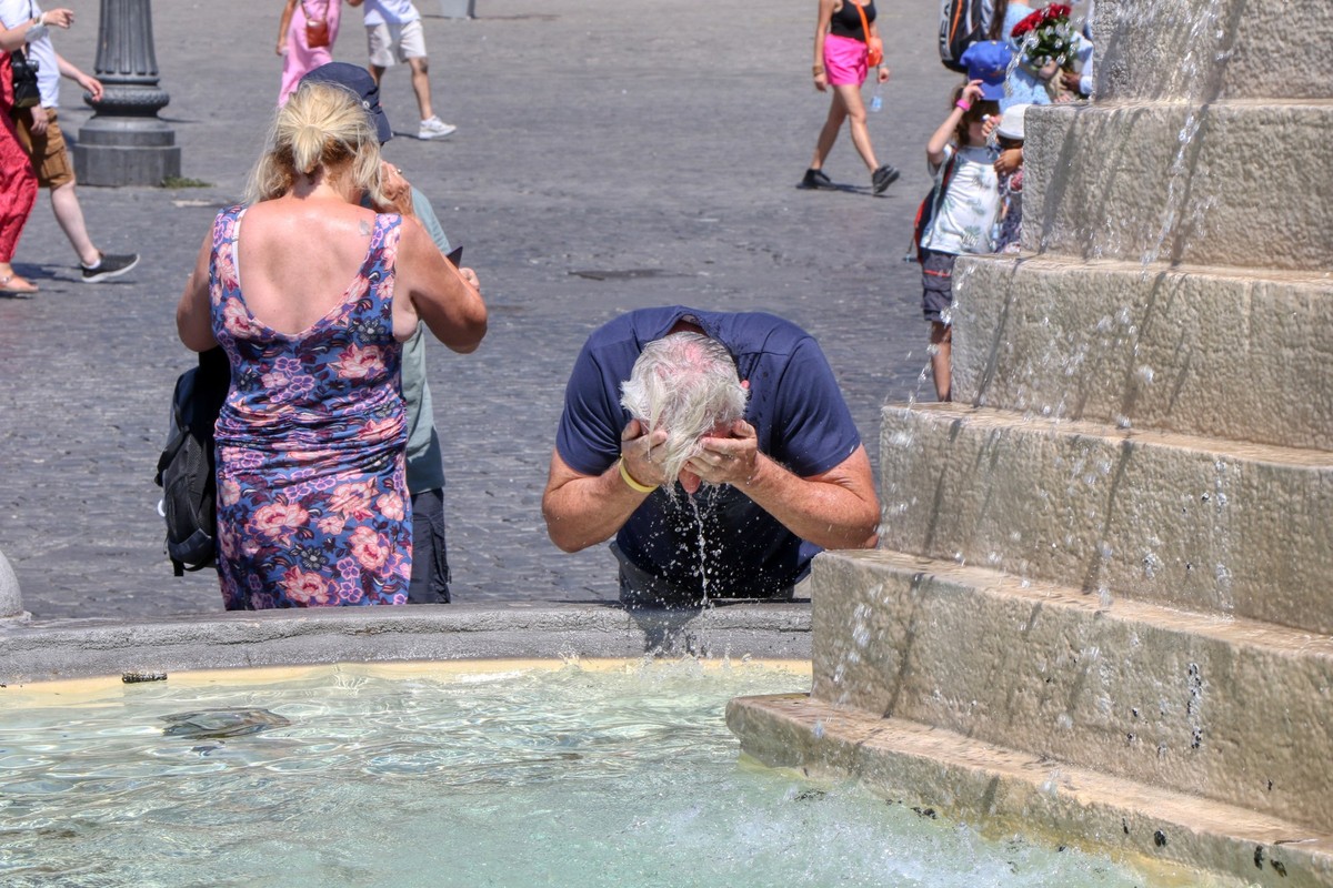 Ein Tourist versucht sich in einem Brunnen abzukühlen.