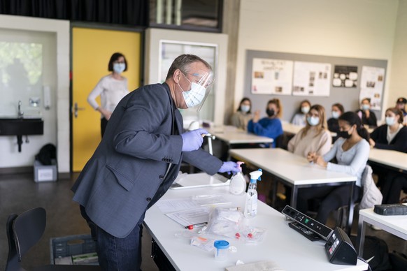 Daniel Meier, Poolmanager eines Corona PCR-Speichelpooltests, erklaert mit Schutzausruestung der Klasse 6D an der Kantonsschule Wiedikon wie der Speichelpooltest funktioniert, fotografiert am Dienstag ...