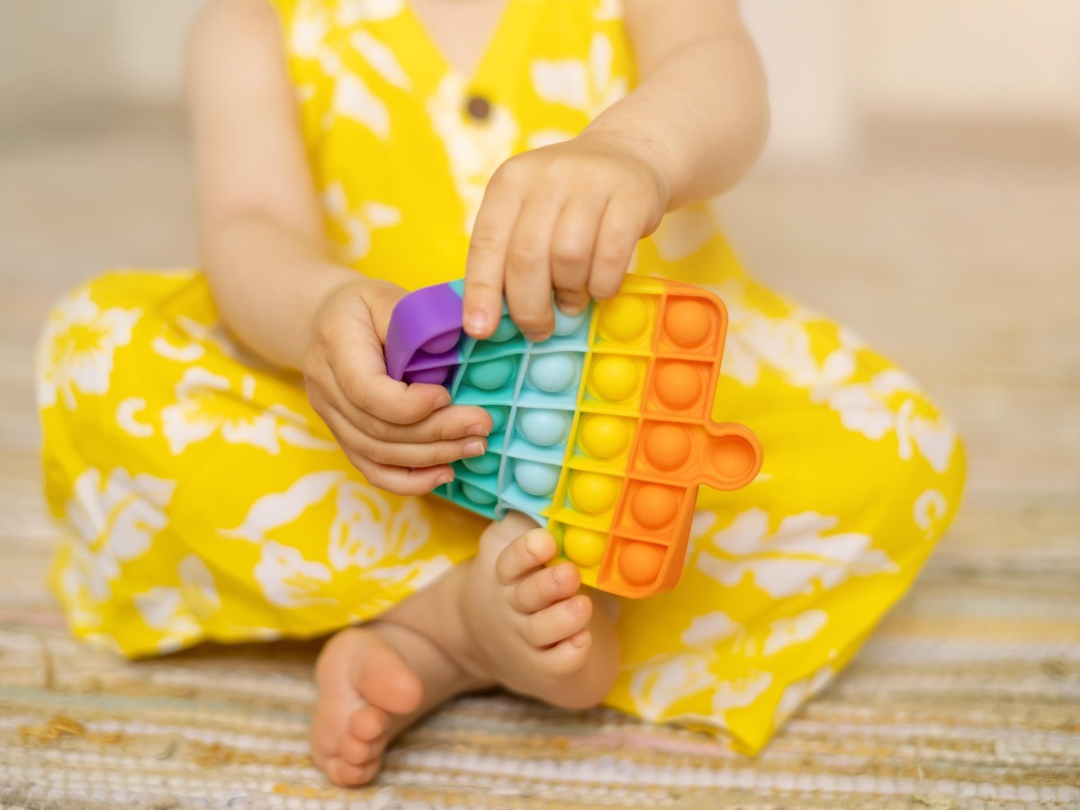 pop it ist ein buntes Anti-Stress-Spielzeug in Kinderhänden