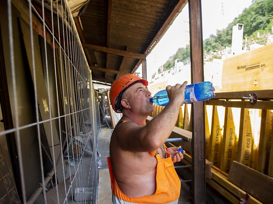 Viel trinken: Ein Arbeiter auf einer Strassenbaustelle im Tessin versorgt sich mit Wasser.