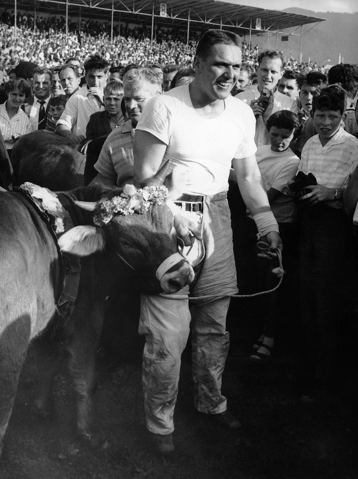 Karl Meli aus Winterthur, mit seiner Trophae, einem 'Munni', wurde Schwingerkoenig am Eidgenoessischen Schwing- und Aelplerfest in Zug 1961. 250 Schwinger aus allen Teilen der Schweiz kaempf ...