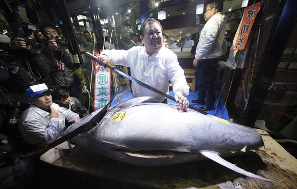 Kiyoshi Kimura, center, president of Kiyomura Co., poses with the bluefin tuna he bought at the annual New Year auction, at his Sushi Zanmai restaurant near Tsukiji fish market in Tokyo early Friday,  ...