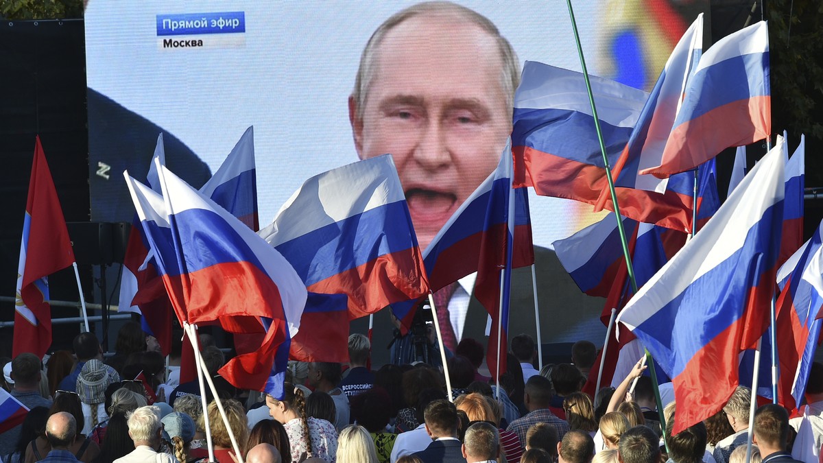 FILE - People watch as Russian President Vladimir Putin delivers his speech after a ceremony to sign the treaties for four regions of Ukraine to join Russia in the Moscow's Kremlin, during a meet ...