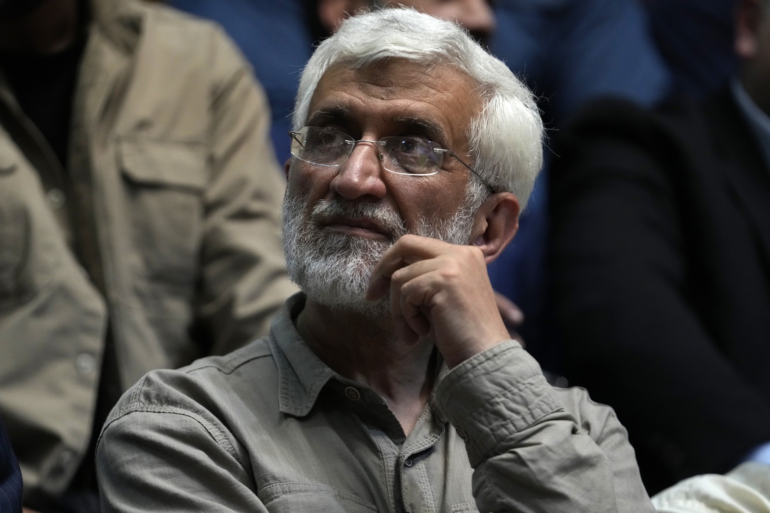 Candidate for the presidential election Saeed Jalili, a former Iranian top nuclear negotiator, listens to a speaker during his campaign meeting at a sports hall in Tehran, Iran, Sunday, June 30, 2024. ...