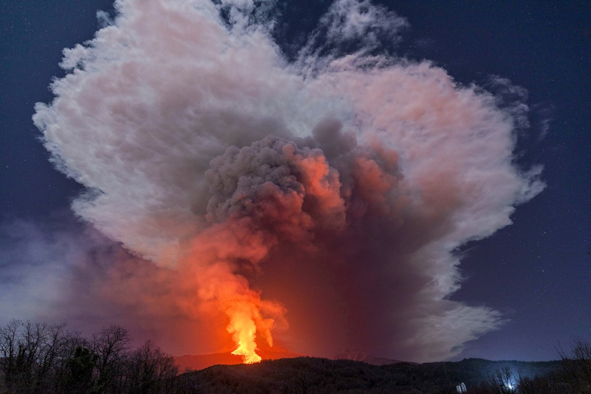 A fiery river of glowing lava flows on the north-east side of the Mt Etna volcano engulfed with ashes and smoke near Milo, Sicily, Wednesday night, Feb. 24, 2021. Europe's most active volcano has ...