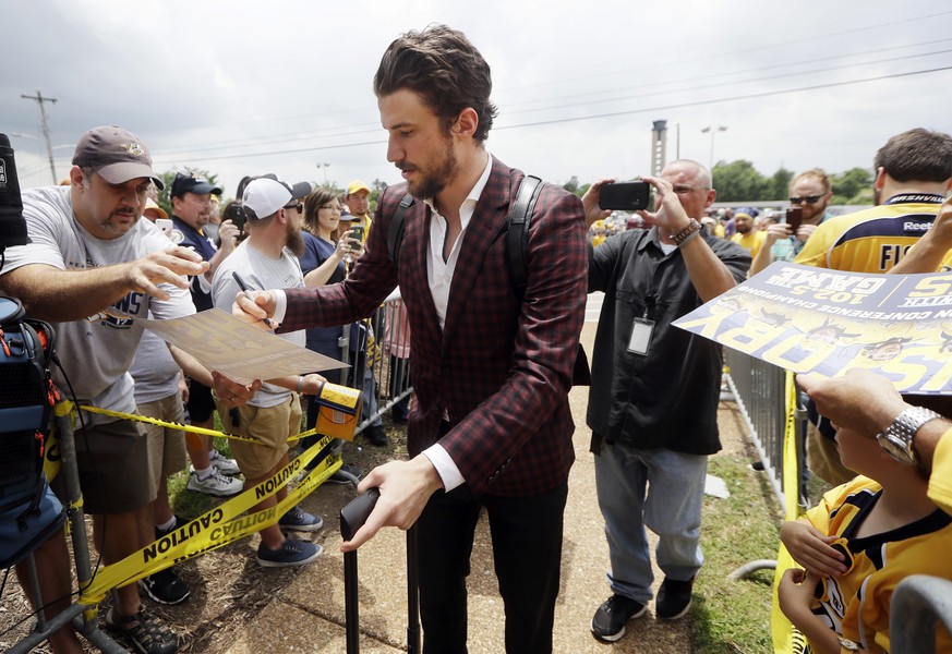 Nashville Predators defenseman Roman Josi, of Switzerland, signs autographs as he arrives at the airport Saturday, May 27, 2017, in Nashville, Tenn., for their flight to Pittsburgh for the NHL hockey  ...