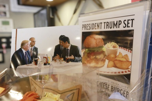 A photo showing U.S. President Donald Trump, left, and Japanese Prime Minister Shinzo Abe, right, at a lunch of hamburgers from Munch&#039;s Burger Shack at Kasumigaseki Country Club, is displayed at  ...