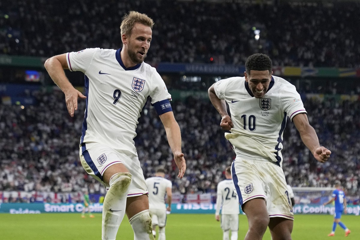 England's Harry Kane, left, celebrates with Jude Bellingham after scoring his side's second goal during a round of sixteen match between England and Slovakia at the Euro 2024 soccer tourname ...