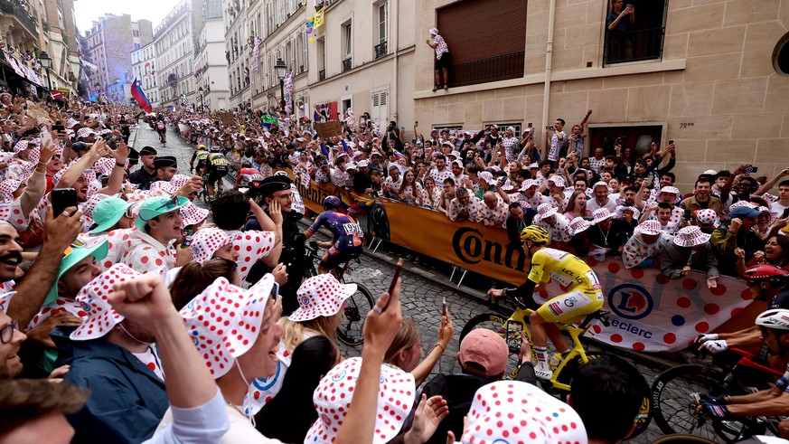 epa12266246 Yellow Jersey overall leader Slovenian rider Tadej Pogacar of UAE Team Emirates is cheered by spectators as the cyclists ride through Paris&#039; Montmartre district where the 21st and las ...