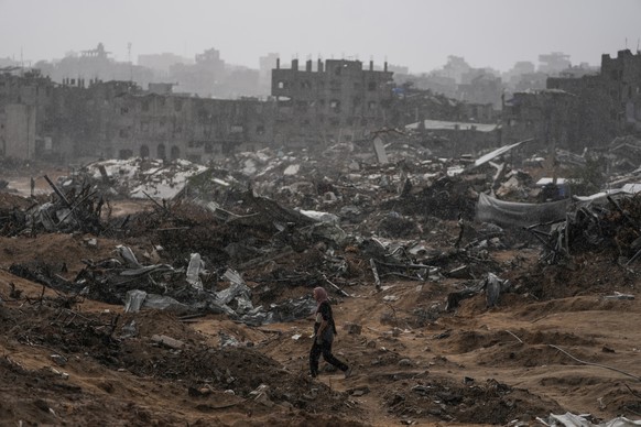 A Palestinian woman walks through a rainstorm past buildings destroyed in Israeli strikes in the Sheikh Radwan neighborhood of Gaza City, Friday, Nov. 14, 2025. (AP Photo/Jehad Alshrafi)
APTOPIX Israe ...