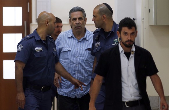 epa06864917 Gonen Segev (C), a former Israeli cabinet minister indicted on suspicion of spying for Iran, is escorted by prison guards as he arrives at court in Jerusalem, Israel, 05 July 2018. EPA/RON ...