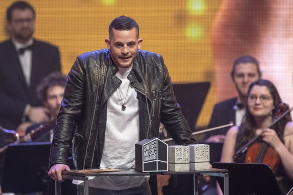 epa07376182 Swiss singer Loco Escrito receives an award for the &#039;Best Hit&#039; during the Swiss Music Awards 2019 ceremony in Lucerne, Switzerland, 16 February 2019. EPA/URS FLUEELER