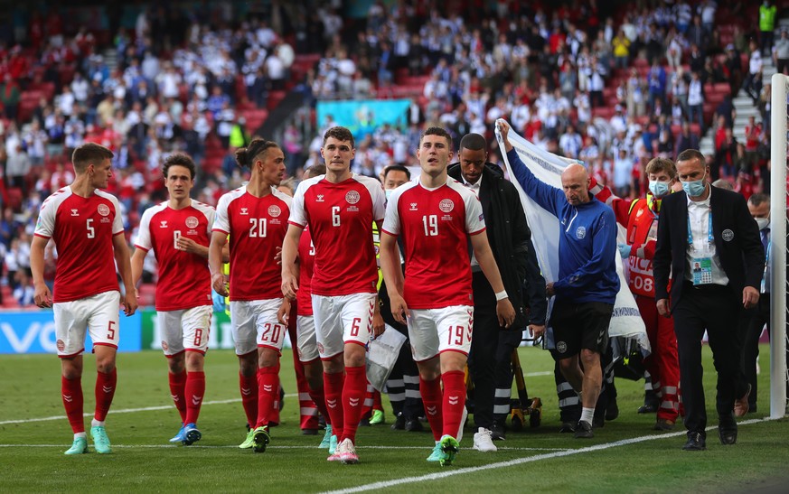 epa09265511 Players of Denmark escort their teammate Christian Eriksen as he is stretchered off the pitch after receiving medical assistance during the UEFA EURO 2020 group B preliminary round soccer  ...