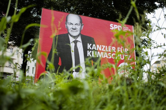 German Social Democratic Party, SPD, candidate for chancellor Olaf Scholz is displayed on an election campaign poster reading: &#039; Chancellor for climate protection&#039;, near a street in Berlin,  ...