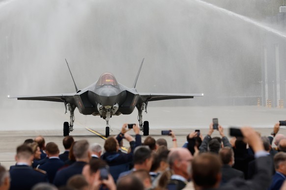 An F-35A Lightning II is sprayed with water on the occassion of the first F-35 fighter jets arriving at the Florennes Airbase in Florennes, Belgium, Monday, Oct. 13, 2025 (AP Photo/Geert Vanden Wijnga ...
