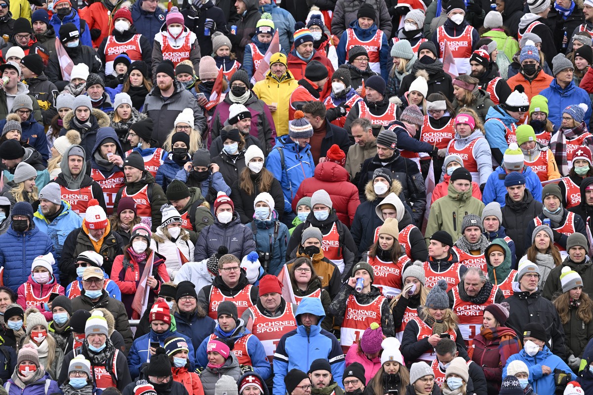 epa09673497 The spectators with or without protective masks stand in the finish area during the second run of the men's giant slalom race at the Alpine Skiing FIS Ski World Cup in Adelboden, Swit ...