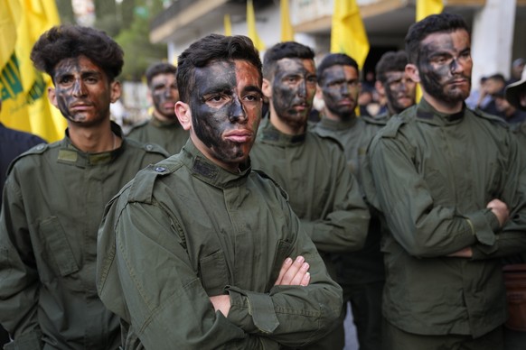 FILE - Hezbollah fighters attend the funeral procession of their two comrades who were killed by Israeli shelling, in Kherbet Selem village, south Lebanon, Tuesday, Oct. 10, 2023. (AP Photo/Hussein Ma ...