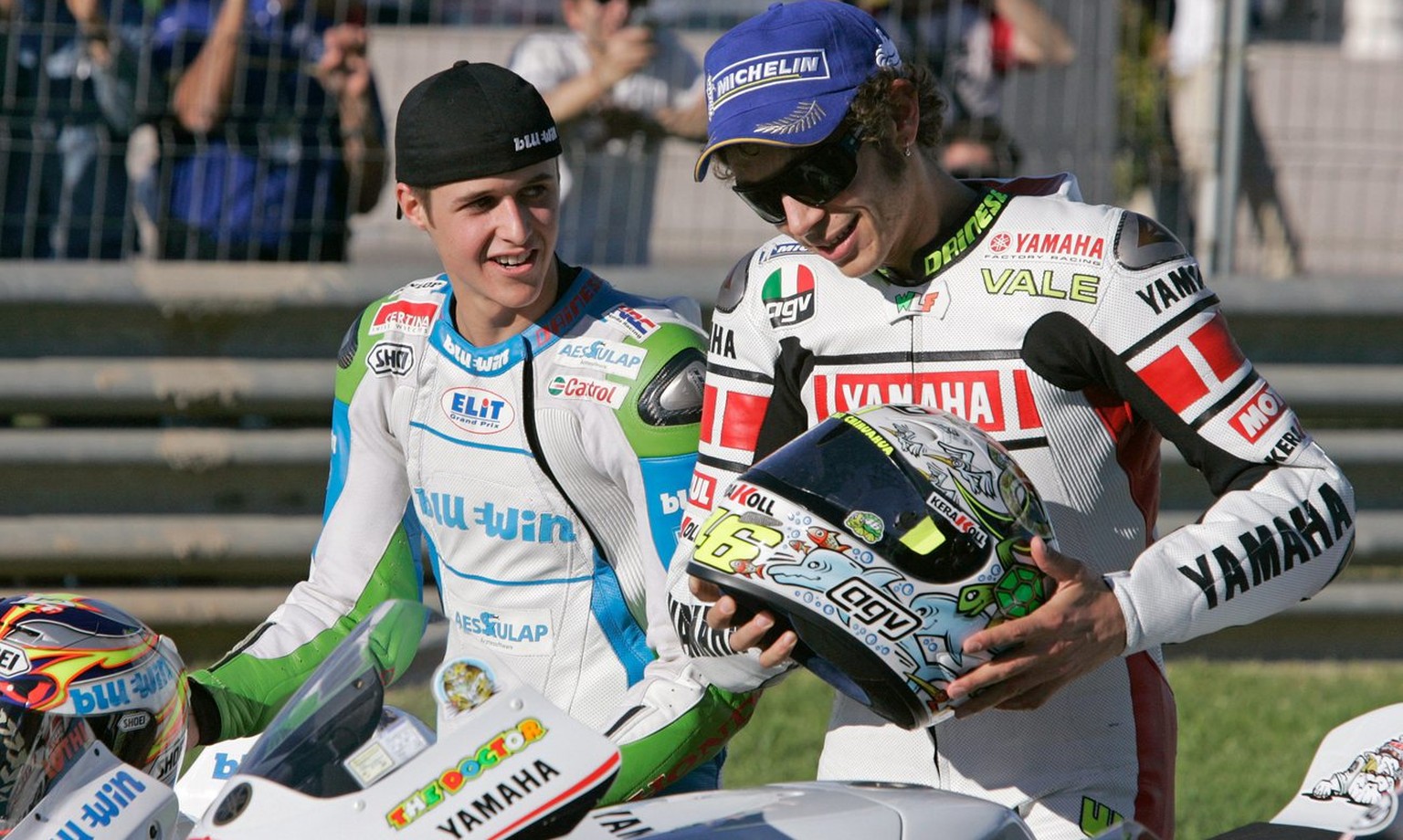Newly crowned 125cc World Champion, Swiss motorcycle pilot Thomas Luethi, left, and MotoGP World Champion Valentino Rossi from Italy place their helmets onto their bikes for a end of season photo sess ...